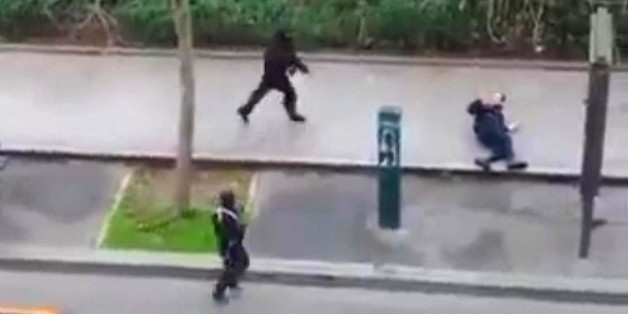 Masked gunman run towards a victim of their gun fire outside the French satirical newspaper Charlie Hebdo's office, in Paris, Wednesday, Jan. 7, 2015. Paris residents captured chilling video images of two masked gunmen shooting a police officer after an attack at a French satirical newspaper. In the video, the gunmen armed with assault rifles are seen running up to an injured police officer, who lies squirming on the ground. The police officer raises his hands up before one of the assailants shoots him in the head at a close range. (AP Photo) NO SALES