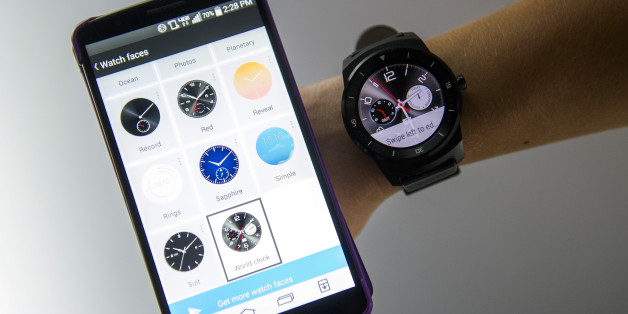 An exhibitor demonstrates an LG G Watch R smartwatch, manufactured by LG Electronics Inc., right, alongside an LG smartphone during the 2015 Consumer Electronics Show (CES) in Las Vegas, Nevada, U.S., on Wednesday, Jan. 7, 2015. This year's CES will be packed with a wide array of gadgets such as drones,connected cars, a range of smart home technology designed to make everyday life more convenient and quantum dot televisions, which promise better color and lower electricity use in giant screens. Photographer: David Paul Morris/Bloomberg via Getty Images