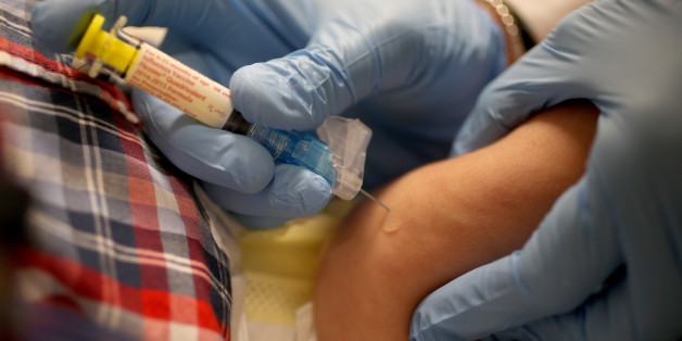 CORAL GABLES, FL - JANUARY 07: Pediatrician Dr. Amanda Porro M.D. delivers a flu vaccination to an infant's leg during his visit to the Miami Children's Hospital on January 7, 2015 in Coral Gables, Florida. The Centers for Disease Control and Prevention announced that in the United States the virus that causes the flu is particularly bad this year and has hit most parts of the United States, with 43 states experiencing 'widespread' flu activity and six others reporting 'regional' flu activity.