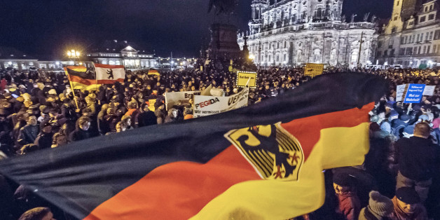 Participants of a rally called 'Patriotic Europeans against the Islamization of the West' (PEGIDA) hold German flags and lights during a demonstration entitled âChristmas With Pegidaâ between the bronze equestrian statue of King John of Saxony, left, and the Dresden Cathedral, or the Cathedral of the Holy Trinity, in Dresden, eastern Germany, Monday, Dec. 22, 2014. For the past ten weeks, activists protesting Germanyâs immigration policy and the spread of Islam in the West have be