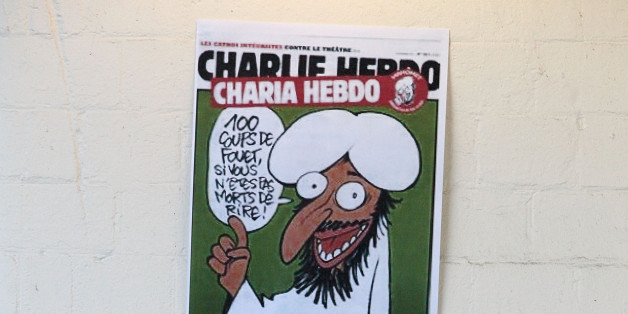 Publishing director of the satyric weekly Charlie Hebdo, Charb, displays the front page of the newspaper as he poses for photographers in Paris, Wednesday, Sept. 19, 2012. Police took up positions outside the Paris offices of the satirical French weekly that published crude caricatures of the Prophet Muhammad on Wednesday that ridicule the film and the furor surrounding it. The provocative weekly, Charlie Hebdo, was firebombed last year after it released a special edition that portrayed the Prop