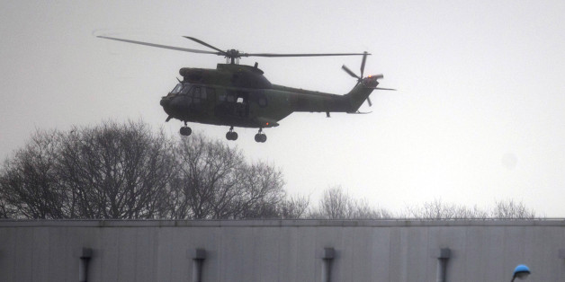 A military helicopter flies over Dammartin-en-Goele, northeast of Paris, Friday Jan. 9, 2015. Brothers suspected in a newspaper terror attack were cornered with a hostage inside a printing house on Friday, after they hijacked a car and police followed them to a village near Paris' main airport. (AP Photo/Peter Dejong)