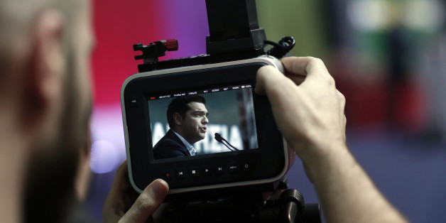 A visitor records a speech by Alexis Tsipras, leader of the Syriza party, during a pre-election party congress in Athens, Greece, on Saturday, Jan. 3, 2015. Greece's political parties embarked on a flash campaign for elections in less than three weeks that Prime Minister Antonis Samaras said will determine the fate of the countrys membership in the euro currency area. Photographer: Kostas Tsironis/Bloomberg via Getty Images