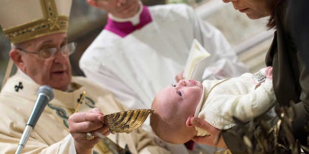 Pope Francis, left, baptizes a baby at the Vatican, Sunday, Jan. 11, 2015. Pope Francis on Sunday baptized 33 babies in the Sistine Chapel as part of an annual tradition, this year repeating an invitation to mothers to nurse their babies if crying out of hunger. For the first time in his pontificate, Francis celebrated Mass with his back to the faithful, according to the rites before the modernizing reforms of the Second Vatican Council in the 1960s. (AP Photo/L'Osservatore Romano, pool)