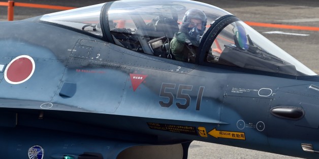 Japan Air Self-Defense Force F-2A/B fighter aircraft pilot salutes during a review ceremony at the Hyakuri air base in Omitama, Ibaraki prefecture on October 26, 2014. Japan's Prime Minister Shinzo Abe spoke at a military review on October 26, renewing his pledge to pursue the controversial shift in the nation's military stance. AFP PHOTO / KAZUHIRO NOGI (Photo credit should read KAZUHIRO NOGI/AFP/Getty Images)
