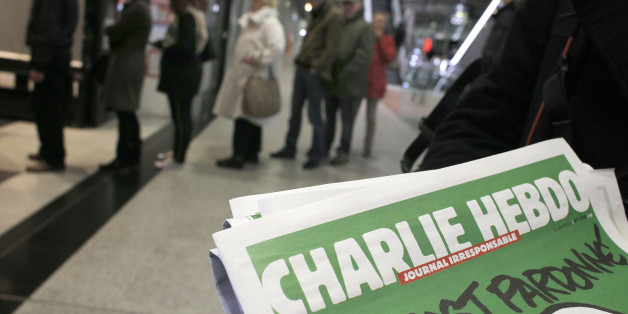 People queue up to buy the new issue of Charlie Hebdo newspaper at a newsstand in Paris Wednesday, Jan. 14, 2015. Charlie Hebdo's defiant new issue sold out before dawn around Paris on Wednesday, with scuffles at kiosks over dwindling copies of the paper fronting the Prophet Muhammad. In the city still shaken by the deaths of 17 people at the hands of Islamic extremists, a controversial comic who appeared to be praising the men was taken into custody. (AP Photo/Christophe Ena)