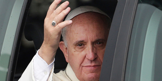 Pope Francis waves from his vehicle as his motorcade returns to his residence following his first mass at the Manila Cathedral Friday, Jan. 16, 2015 in Manila, Philippines. Pope Francis arrived Thursday for a five-day apostolic visit in this predominantly Catholic nation in Asia. (AP Photo/Bullit Marquez)