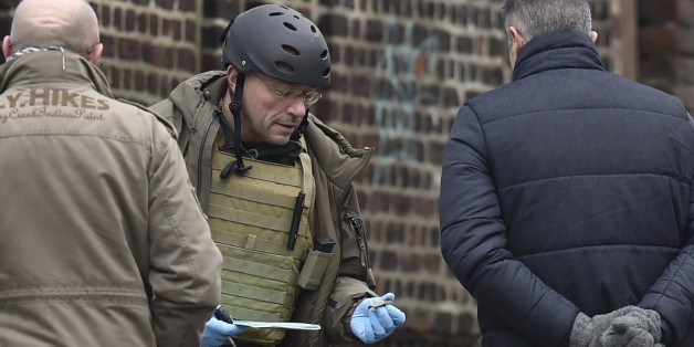 Members of the forensic team work at Colline street in Verviers, eastern Belgium, on January 16, 2015, after police shot dead two suspects in a gun battle after they opened fire on officers with heavy weapons, and arrested a third man. Belgian police arrested 13 people during a dozen raids overnight, smashing plot to kill police officers 'in public roads and in police stations', prosecutors said. AFP PHOTO / JOHN THYS (Photo credit should read JOHN THYS/AFP/Getty Images)