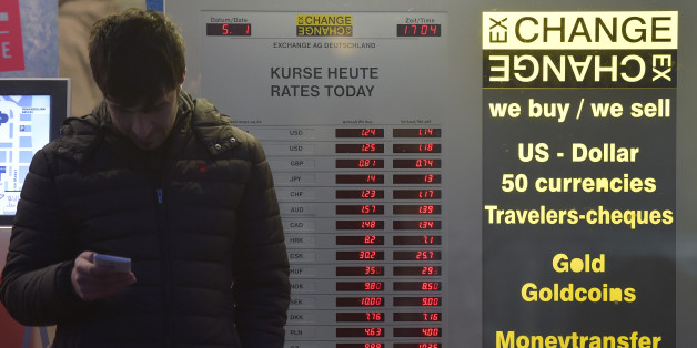The exchange rate of the US Dollar is displayed in the window of a currency exchange office in Cologne, Monday, Jan. 5, 2015. The euro sank to a nine-year low Monday as new doubts surfaced about Greece's commitment to the common currency bloc. European stocks mostly rose while Asian markets were mixed. (AP Photo/Martin Meissner)