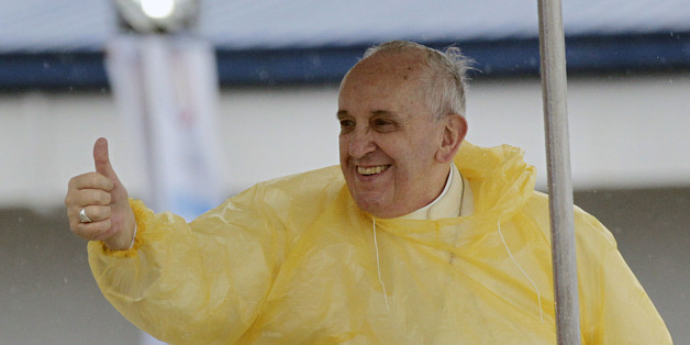 Wearing a yellow raincoat, Pope Francis gives a thumbs up to the faithful as he arrives in Tacloban, Philippines, Saturday, Jan. 17, 2015. A rain-drenched but lively crowd wearing yellow and white raincoats welcomed Pope Francis in the typhoon-ravage central Philippine city of Tacloban early Saturday, chanting "Papa Francesco, Viva il Papa!" (AP Photo/Wally Santana)