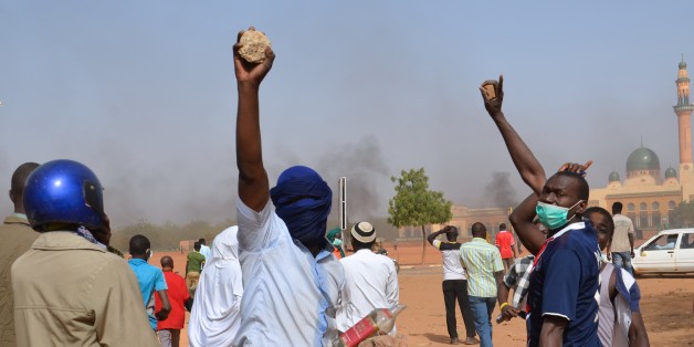 People holds rocks as they demonstrate against French weekly Charlie Hebdo's publication of a cartoon of the Prophet Mohammed near the grand mosque in Niamey, on January 17, 2015. At least 1,000 youths assembled at the grand mosque in the capital Niamey, some of them throwing rocks at police while others burned tyres and chanted 'Allahu Akbar' ('God is Greatest'). The protest came a day after a policeman and three civilians were killed and 45 injured in protests against Charlie Hebdo in Niger's second city of Zinder, which saw three churches ransacked and the French cultural centre burned down.
AFP PHOTO / BOUREIMA HAMA (Photo credit should read BOUREIMA HAMA/AFP/Getty Images)