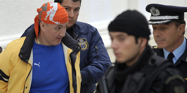 A file picture taken on November 3, 2009 shows Panayotis Vlastos (L) escorted by special police forces after his arrest. Vlastos, a Greek crime godfather and several anarchist fellow inmates took three guards hostage late on December 12, 2011 in an Athens jail following a failed escape, but released them after an hours-long standoff, officials said. Vlastos, considered the brains behind the 2009 kidnapping of septuagenarian shipping magnate Pericles Panagopoulos, got hold of the gun smuggled i