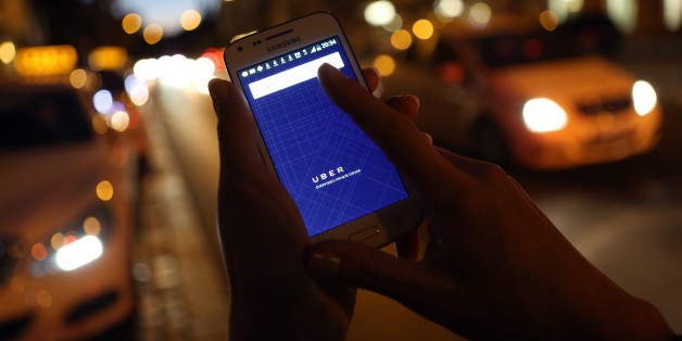 BERLIN, GERMANY - SEPTEMBER 02: In this photo illustration, a woman uses the Uber app on an Samsung smartphone on September 2, 2014 in Berlin, Germany. Uber, an app that allows passenger to buy rides from drivers who do not have taxi permits, has had its UberPop freelance driver service banned in Germany after a complaint by Taxi Deutschland, a trade association of taxi drivers in the country. The company, which operates in 42 countries over 200 cities worldwide, plans to both appeal the decisi