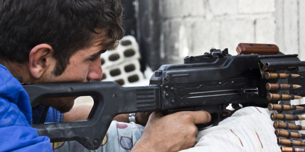 In this Wednesday, Nov. 19, 2014 photo, a young Kurdish People's Protection Units (YPG) fighter who recently volunteered holds a position with a PKM in Kobani, Syria. Here, Kurdish fighters backed by small numbers of Iraqi peshmerga forces and Syrian rebels, are battling what they see as an existential battle against the militants who swept into their town in mid-September as part of a summer blitz that saw the group seize large chunks of territory in Syria and neighboring Iraq.(AP Photo/Jake Simkin)