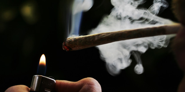 FILE - In this June 24, 2008 file photo a regular user of soft drugs demonstrates how to smoke a marijuana joint in a coffee shop in Amsterdam, Netherlands. Dutch coffee shops owners went to court Wednesday in a last ditch bid to block a government plan to stop foreigners from buying marijuana in the Netherlands. Lawyers representing the coffee shops oppose what would be the most significant change in decades to the country's famed soft drug tolerance: turning marijuana cafes into "members only" clubs open solely to Dutch residents. Members would only be able to get into the coffee shops by registering for a "weed pass" and the shops would only be allowed a maximum of 2,000 members. (AP Photo/Peter Dejong, File)