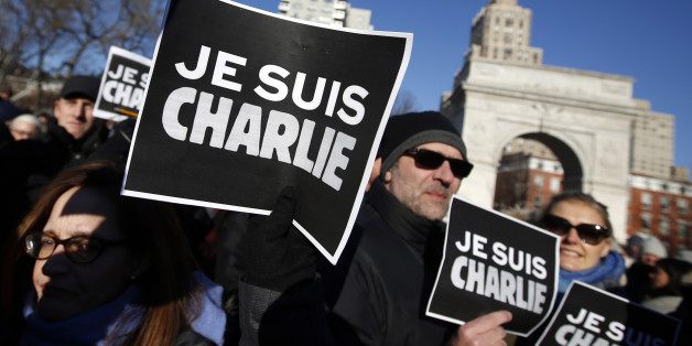 Attendees hold "Je Suis Charlie" (I am Charlie) signs as several hundred people gather in solidarity with victims of two terrorist attacks in Paris, one at the office of weekly newspaper Charlie Hebdo and another at a kosher market, in New York's Washington Square Park, Saturday, Jan. 10, 2015. (AP Photo/Jason DeCrow)