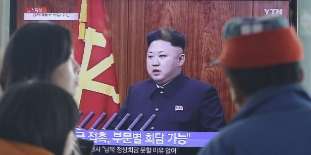 People watch a TV news program showing North Korean leader Kim Jong-Un delivering a speech, at the Seoul Railway Station in Seoul, South Korea, Thursday, Jan. 1, 2015. Kim, in a nationally televised New Year's Day speech, says he is open to a summit with his South Korean counterpart. The letters read: "Meeting." (AP Photo/Ahn Young-joon)