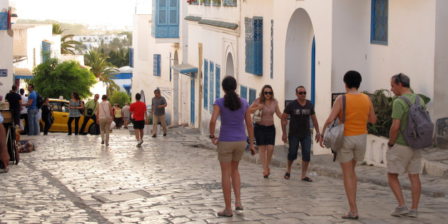 Tunisian and foreign tourists wander through the picturesque town of Sidi Bou Said just outside the Tunisian capital of Tunis on July 1, 2012. After a disastrous year in which revolution, social upheaval and strikes scared away tourists and crippled industrial production, the economy is slowly climbing out of a deep recession that saw it shrink by 2 percent in 2011. (AP Photo/Paul Schemm)