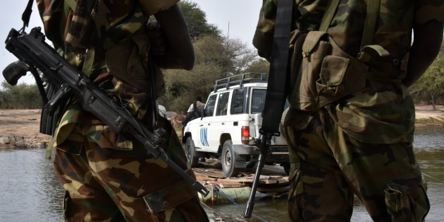 A picture taken on January 27, 2015 shows Chadian soldiers watching as a UN vehicle from a United Nations' refugee agency (UNHCR) convoy crosses a branch of lake Chad, heading to the UNHCR camp in N'Gouboua, in Chad's Lake Chad region. Since the beginning of January more than 14,000 people have fled over the Nigerian border into Chad to escape the bloody attacks by Islamist group Boko Haram around Baga, according to Mamadou Dian Balde, of the UN's refugee agency. AFP PHOTO/ SIA KAMBOU (Photo credit should read SIA KAMBOU/AFP/Getty Images)