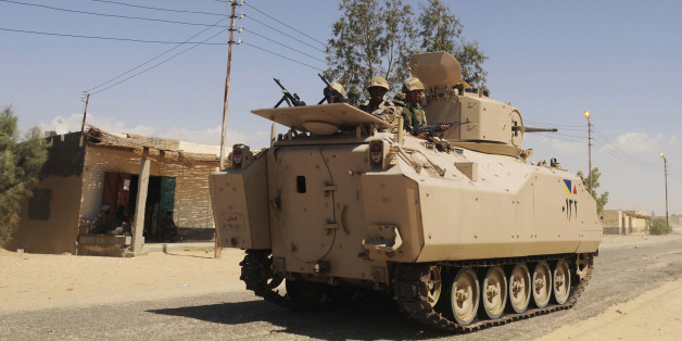 FILE - In this Tuesday, May 12, 2013 file photo, Egyptian Army soldiers patrol in an armored vehicle backed by a helicopter gunship during a sweep through villages in Sheikh Zuweyid, north Sinai, Egypt. An Egyptian militant group affiliated with the Islamic State has claimed responsibility for coordinated and simultaneous attacks Thursday, Jan. 29, 2015 that struck more than a dozen army and police targets in three towns in the restive Sinai Peninsula, killing at least 26 security officers. Following the attack, el-Sissi cut short a trip to Ethiopia, to return to Cairo, MENA reported Friday. (AP Photo, File)