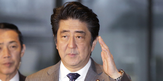 Japan's Prime Minister Shinzo Abe, right, arrives at the prime minister's official residence in Tokyo, Friday, Jan. 30, 2015. (AP Photo/Eugene Hoshiko)