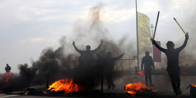 FILE - In this Monday, Dec. 30, 2013, file photo, Iraqi Sunni masked protesters burn tires to block the main highway to Jordan and Syria, outside Fallujah, Iraq. More than a month after jihadist militants seized control of parts of Iraqâs western Anbar province, an unsettling realization is sinking in: Iraqâs government could face a tougher time beating back an insurgency there than the hard slog the Americans faced last decade. The reasons include a deep distrust of the government by Iraqi Sunnis, insufficient resources, sectarian tensions enflamed by the war in Syria and divisions among the tribes that make up Anbarâs social fabric. (AP Photo, File)