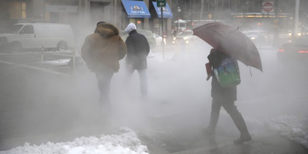 Pedestrians make their way around lower Manhattan on slushy morning in New York, Monday, Feb. 2, 2015. New York City Mayor Bill de Blasio is warning commuters to be "very cautious" as another winter storm system brings a mix of snow, sleet and freezing rain to the metro area. (AP Photo/Seth Wenig)