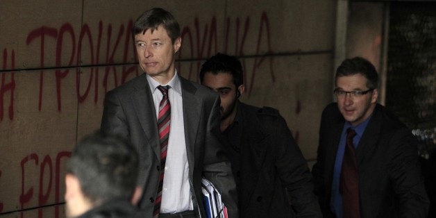 Klaus Masuch of the European Central Bank, right, and European Commission official Matthias Mors, second left, enter the Finance Ministry during a rally in Athens, on Friday, Feb. 28, 2014. Hundreds of teachers, municipality workers, school guards and cleaning women who have been suspended on reduced pay pending transfer to other public sector jobs or dismissal, took part in the protest as the officials from the European Union, European Central Bank and International Monetary Fund, together known as the troika, were holding talks with the Minister of Administration Reform Kyriakos Mitsotakis and other government officials. The conservative-led government has committed to sack thousands of civil servants this year, as part of its austerity commitments to bailout creditors whose rescue loans have kept Greece afloat since 2010. (AP Photo/Thanassis Stavrakis)