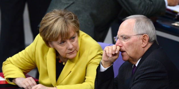 German Chancellor Angela Merkel (L) and German Finance Minister Wolfgang Schaeuble (R) chat during a session of the Lower house of parliament Bundestag on November 28, 2014 at the Reichstag building in Berlin before a vote to approve the budget blueprint for 2015. AFP PHOTO / JOHN MACDOUGALL (Photo credit should read JOHN MACDOUGALL/AFP/Getty Images)