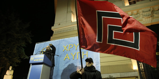 Ilias Panagiotaros, left, a member of the Greek Parliament of the extreme far-right party Golden Dawn, gestures as he talks during a rally to commemorate a 1996 incident which cost the lives of three Greek navy officers and brought Greece and Turkey to the brink of war, in central Athens, Saturday, Jan. 31, 2015. The extreme right, anti-immigrant Golden Dawn party, which has Nazi roots, received the third-place in Sunday, Jan. 25's election. Its showing comes despite the fact that the party's leader and most of its lawmakers are behind bars, facing charges of participating in a 'criminal organization' accused of murders, brutal attacks on migrants and others, extortion and arson. (AP Photo/Lefteris Pitarakis)