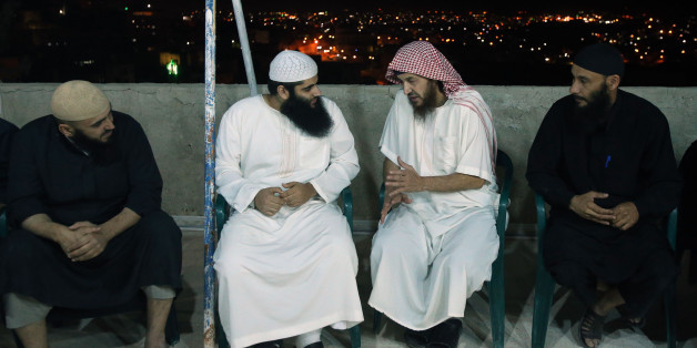 YAJUZ, JORDAN- JUNE 16: Essam Barqawi (2nd from R), known as Abu Mohammad Al Maqdessi, talks with Qatada, the eldest son of the radical cleric Abu Qatada, who was deported to Jordan from the UK in July 2013, as Al Maqdisi is receiving guests greeting him at his home June 16, 2014 in Yajuz, east of Amman, Jordan. Jordan released the leading jihadist ideologist Al Maqdisi, who was once mentor to Iraq's now slain Al Qaida leader, on Monday after he completed a jail sentence for recruiting fighters for the Taliban. (Photo by Jordan Pix/ Getty Images)