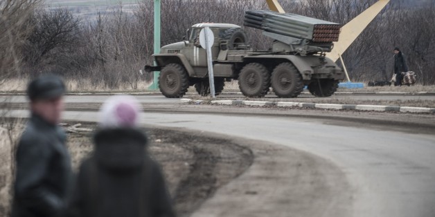 A Ukrainian multiple rocket launcher system BM-21 "Grad" is driven on a road near Artemivsk, eastern Ukraine, Thursday, Feb. 5, 2015. Fighting between Russia-backed separatists and Ukrainian forces in eastern Ukraine surged in January, raising the death toll to over 5,300 people killed since April. In a new push for peace, the leaders of France and Germany headed Thursday to Kiev and Moscow with a proposal to end the fighting in eastern Ukraine. (AP Photo/Evgeniy Maloletka)