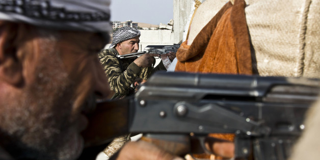 FILE - In this Wednesday, Nov. 19, 2014 file photo, fighters from the Free Syrian Army, left, and the Kurdish People's Protection Units (YPG), center, join forces to fight Islamic State group militants in Kobani, Syria. Kurdish fighters backed by intense U.S.-led airstrikes pushed the Islamic State group almost entirely out of the Syrian town of Kobani on Monday, Jan. 26, 2015, marking a major loss for extremists whose hopes for easy victory dissolved into a bloody, costly siege that seems close to ending in defeat. (AP Photo/Jake Simkin, File)