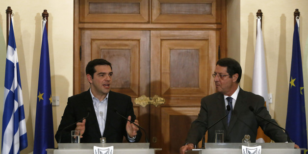 Greek Prime Minister Alexis Tsipras, left, speaks to the media as Cyprus' president Nicos Anastasiades listens during a press conference after their meeting at the Presidential Palace in the capital Nicosia, Monday, Feb. 2, 2015. Tsipras is visiting Cyprus, his first trip abroad as prime minister since his election last month. It's customary for all newly-elected Greek prime ministers to conduct their first trip abroad to Cyprus because of the two countries' deep historic ties. (AP Photo/Petros Karadjias)
