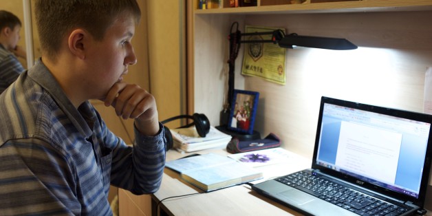 In this photo taken on Friday, Nov. 28, 2014, Denis Akimov, 15, sits in front of his laptop at home in Donetsk, eastern Ukraine. Like most children his age, Denis Akimov spends hours daily on his computer surfing the Internet. It isnât just for fun. As schools are forced to limit operations in the conflict-battered eastern Ukrainian city of Donetsk, educators are turning to the Web to keep their charges learning. (AP Photo/Balint Szlanko)