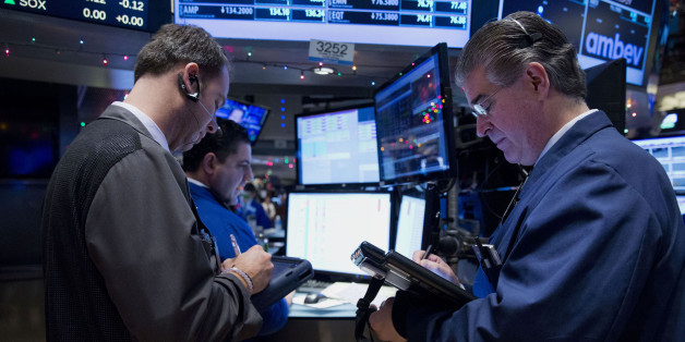 Traders work on the floor of the New York Stock Exchange (NYSE) in New York, U.S., on Wednesday, Dec. 31, 2014. U.S. stocks were little changed on the last trading day of a year that capped the biggest bull market since the 1990s. Photographer: Jin Lee/Bloomberg via Getty Images