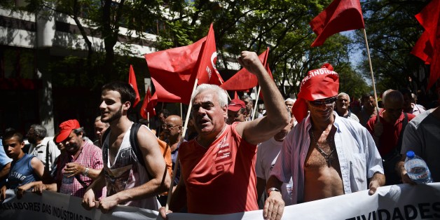 Demonstrators march holding flags during a demonstration called by the CGTP union (General Confederation of the Portuguese Workers) against the austerity measures of the Portuguese government in Lisbon on July 10, 2014. AFP PHOTO/ PATRICIA DE MELO MOREIRA (Photo credit should read PATRICIA DE MELO MOREIRA/AFP/Getty Images)