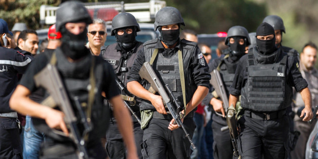 Members of the Tunisian National Guard take positions as they secure the scene of a shooting in the Oued Ellil suburb of Tunis, Tunisia, Thursday, Oct. 23, 2014. A Tunisia official says a security officer has been killed in a shootout that began when a suspect's home was surrounded near the capital. Interior Ministry spokesman Mohammed Ali Aroui says the exchange of fire Thursday came after a pair of counterterrorism operations in the south that left one bystander dead. (AP Photo/Aimen Zine)