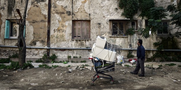 TO GO WITH AFP STORY BY HELEN COLLIOPOULOU
A man waits for help to unload scrap he found at the prosfygika complex in central Athens on Novemeber 2, 2014 .Wedged between the Supreme Court of Greece and the Athens Police Headquarters this is hardly the place you would imagine Greek and immigrant squatters. This architectural marvel dating back to the 30s originally built for Greek refugees fleeing Turkey after World War I is known as Prosfygika meaning Refugee House in Greek. Immigrants started to occupy these units since 2005 , while Greek squat since the beginning of the crisis in 2010. 'The particular arrangement of these buildings help to feel and share a community life on the principles of equality and solidarity ' , a greek squatter Vangelis says. AFP PHOTO/ LOUISA GOULIAMAKI (Photo credit should read LOUISA GOULIAMAKI/AFP/Getty Images)