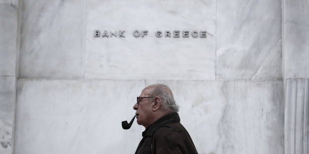 A man walks past the Bank of Greece headquarters, in central Athens, on Wednesday, Feb. 4, 2015. With all Europe waiting to see how Greece proposes to renegotiate its massive bailout loans, Greece's Prime Minister Alexis Tsipras and his Finance Minister Yanis Varoufakis are on a whirlwind tour of the region to discuss possible solutions. Tsipras wants easier terms of repayment on the 240 billion euros (currently $271 billion) in bailout loans and to ease back on the austerity budget measures th