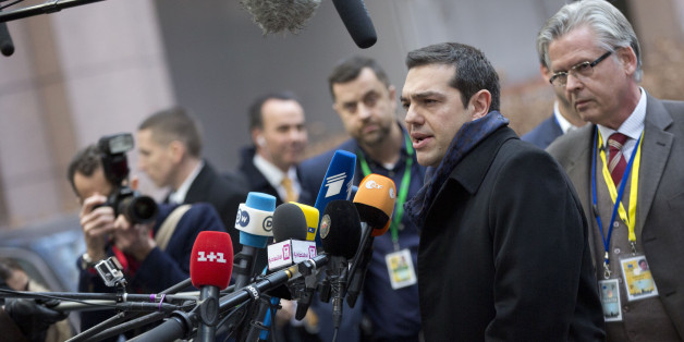 Greek Prime Minister Alexis Tsipras, second right, speaks with the media as he arrives for an EU summit in Brussels on Thursday, Feb. 12, 2015. EU leaders meet for a one-day summit on Thursday to discuss, among other issues, European banks and the situation in Ukraine.(AP Photo/Virginia Mayo)