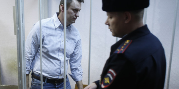 FILE - In this Tuesday, Dec. 30, 2014 file photo, Russian opposition activist Alexei Navalny, 38, enters a cage at a court in Moscow, Russia. Russia's leading opposition figure Alexei Navalny has been sentenced to 15 days in police custody for handing out leaflets in the subway. (AP Photo/Pavel Golovkin, File)