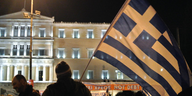 ATHENS, GREECE - 2015/02/15: A demonstrator with a big Greek flag. Greeks demonstrated all over Greece in support of the Greek government efforts to find a new agreement for the national debt and against continuous pressure from IMF and ECB to impose new austerity measures. (Photo by George Panagakis/Pacific Press/LightRocket via Getty Images)