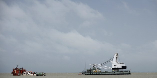 Bangladeshi rescue teams search the waters where an overloaded ferry capsized the day before in the Padma river in Munshiganj, some 30 kilometres (20 miles) south of the capital Dhaka, on August 5, 2014. The ferry carrying up to 200 passengers sank on August 4 in tough conditions on a river in central Bangladesh. Emergency workers said around 100 survivors and two dead bodies had been pulled out of the river, but the rest remain unaccounted for. AFP PHOTO / Munir uz ZAMAN (Photo cred