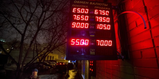 A man walks past an exchange office with a sign advertising currency exchange rates in Moscow, Russia, Tuesday, Jan. 13, 2015. The currency was down more than 4 percent in afternoon trading in Moscow, at around 66 rubles per dollar. The ruble hit a record low of 80 per dollar in mid-December before recovering a bit, but it has been steadily falling since the start of the year. Lines from top indicate the spread on the dollar-ruble rate, the euro-ruble rate, the British pound-ruble rate and the S