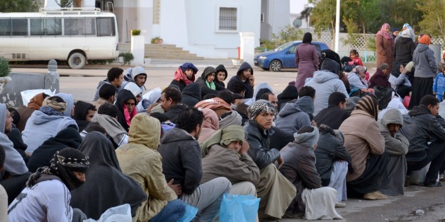 Des travailleurs égyptiens attendent après avoir franchi la frontière tunisienne au poste frontière de Ras Jdir, entre la Libye et la Tunisie, le vendredi 20 février.
