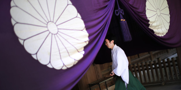 A Shinto priest walks at Yasukuni Shrine during an annual autumn festival in Tokyo, Friday, Oct. 17, 2014. (AP Photo/Eugene Hoshiko).