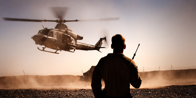 FORWARD OPERATING BASE GERONIMO, Helmand province, Islamic Republic of Afghanistan â Cpl. Michael Lyons, the 3rd Battalion, 3rd Marine Regiment, air noncommissioned officer, monitors the inbound descent of an AH-1W SuperCobra onto the Forward Operating Base Geronimo landing zone in Afghanistan, Nov. 7, 2010. The helicopter transported Marine Light Attack Helicopter Squadron 369âs senior leadership to FOB Geronimo to attend a plaque dedication ceremony in honor of Lt. Col. Mario D. Carazo and Maj. James M. Weis, two pilots from HMLA-369 who were killed in action while supporting 3/3 combat operations in July. (Official Marine Corps photo by Sgt. Mark Fayloga)