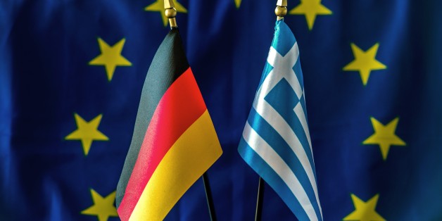 A picture taken on February 23, 2015 shows a German (L) and a Greek flag against a backdrop of a European Union flag in the northern French city of Lille. AFP PHOTO / PHILIPPE HUGUEN (Photo credit should read PHILIPPE HUGUEN/AFP/Getty Images)