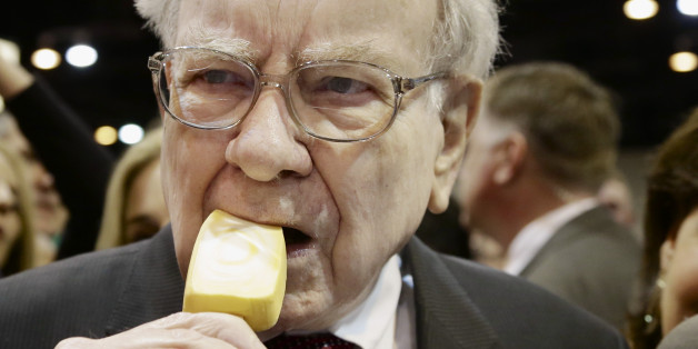 Berkshire Hathaway Chairman and CEO Warren Buffett eats an ice cream bar while touring the exhibition floor prior to the annual shareholders meeting on Saturday, May 3, 2014, in Omaha, Neb. More than 30,000 shareholders are expected to fill the CenturyLink Arena to hear Buffett and Berkshire Vice Chairman Charlie Munger discuss their business. (AP Photo/Nati Harnik)